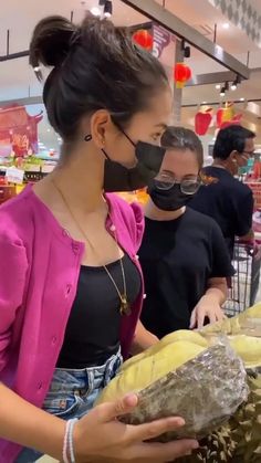 a woman wearing a face mask while shopping in a store with other people behind her