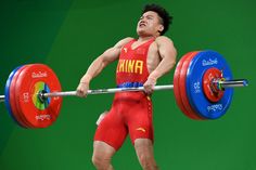 a man in red shorts lifting a barbell on a green screen background with his hands behind his back