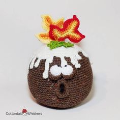 a crocheted pot holder with a flower on it's head and eyes