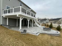 a house with a deck and stairs in the front yard