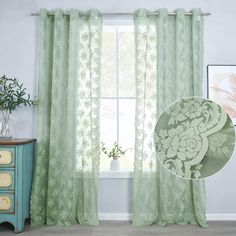 the curtains in this room are green and have floral designs on them, along with a blue chest of drawers