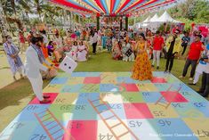 a group of people standing on top of a giant checkerboard dance floor in front of a crowd