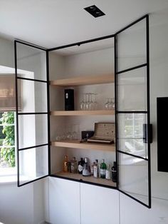 a room with some shelves filled with bottles and glasses