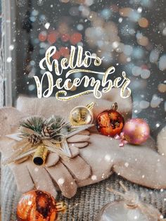 a christmas card with gloves and ornaments on the window sill in front of snow falling