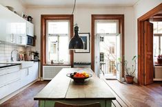 a bowl of fruit is on the kitchen table