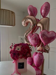 balloons and flowers on a table with the number twenty two in front of it,