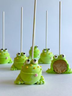 green cake pops with googly eyes and sticks sticking out of them