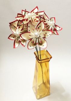 a vase filled with paper flowers on top of a table