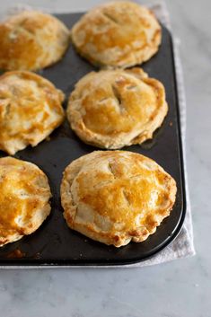 nine baked pastries sitting on top of a baking sheet in a muffin tin