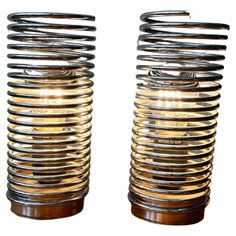 two metal and wood vases sitting side by side