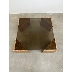 a table made out of plywood and concrete on cement floor with white wall in the background