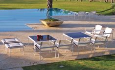 there are many chairs and tables near the pool