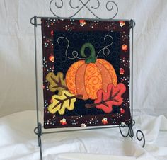 a quilted fall scene with a pumpkin and leaves