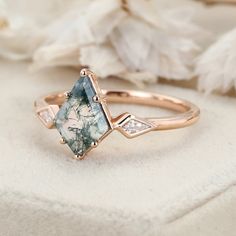 a close up of a ring with an aqua stone and diamonds on it next to some flowers