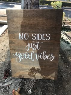 a wooden sign that says no sides just good vibes on the side of a tree