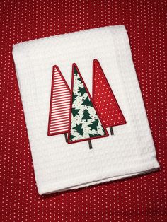 three christmas trees on a red and white polka dot table cloth, one is folded in half