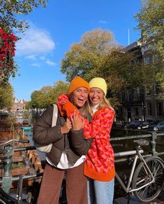 two people standing next to each other on a bridge