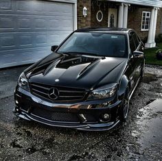 a black car parked in front of a garage