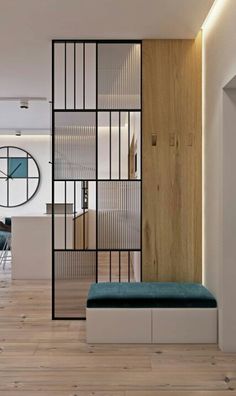 an open concept living room with wooden floors and white walls, along with a blue bench