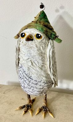 an owl with a green hat on top of it's head and two legs