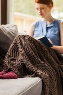 a woman sitting on a couch reading a book