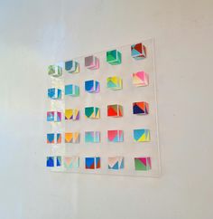 a white wall with many different colored squares on it