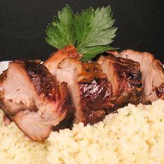 meat and rice on a plate with parsley garnished in the top right corner