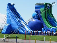 an inflatable water slide with people standing around it