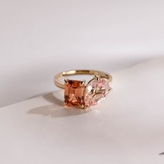 an orange and pink ring sitting on top of a white surface