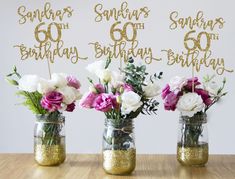 three mason jars with flowers in them on a table