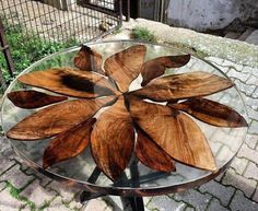 a glass table with wooden leaves on it and the words woodworking projects man cave easy