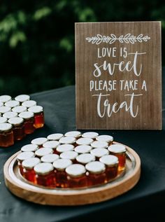 a wooden sign that says love is sweet please take a treat on top of a table