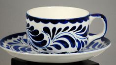 a blue and white coffee cup sitting on top of a saucer