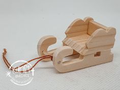 a wooden toy sleigh with a cord attached to it