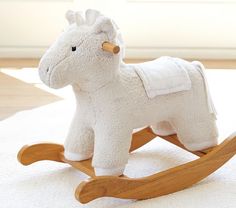 a toy rocking horse with a white blanket on the floor