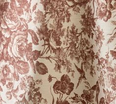 a close up view of a flowered curtain with red and white flowers on it