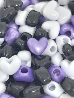 there are many different colors of beads on the table and one is black, white, and purple