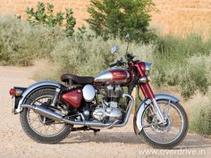 a red and black motorcycle parked in the dirt