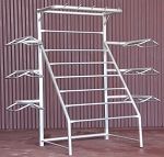 a white metal rack with five shelves and three bars on each side, in front of a purple wall