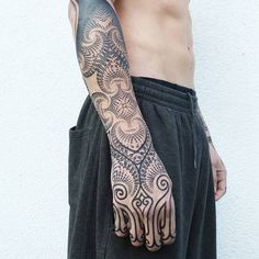 a man with a tattoo on his arm and hand is holding something in his other hand