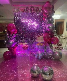 purple and silver party decorations on display in a room with balloons, streamers and disco balls