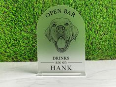 an open bar sign with a dog's head on it and the words drinks are on hank