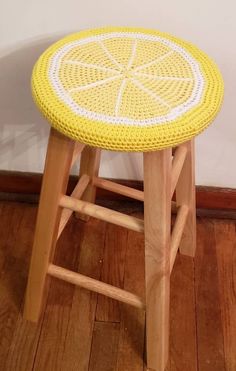 a yellow and white stool sitting on top of a wooden floor