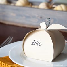 a white plate topped with an apple on top of a table