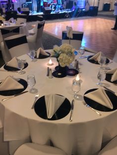 a white table with black and white linens is set up for a formal function