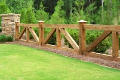 a wooden fence in the middle of a grassy area