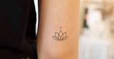 a woman's arm with a small flower tattoo on the left side of her arm