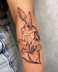 a bird sitting on top of a flower tattoo