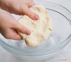 someone is kneading the dough into a glass bowl on top of a table