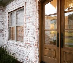 a brick building with two double doors and one side door is open to let in light